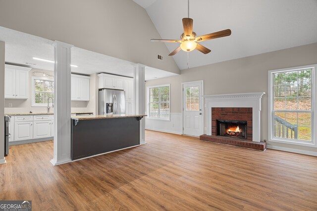 kitchen featuring stainless steel appliances, sink, white cabinets, and light stone counters