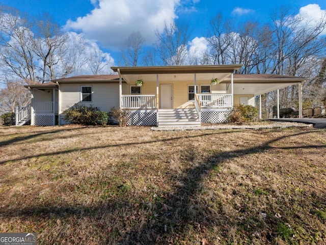 view of front facade featuring a porch, a carport, and a front lawn