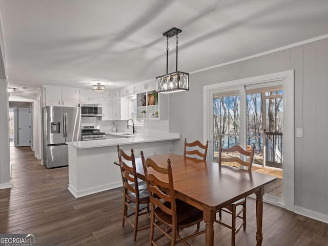 dining room with ornamental molding, dark hardwood / wood-style flooring, and sink