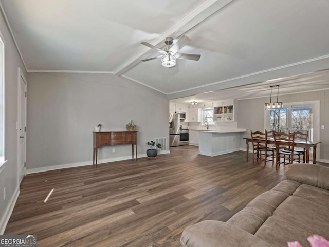 living room with lofted ceiling with beams, plenty of natural light, dark hardwood / wood-style floors, and ceiling fan