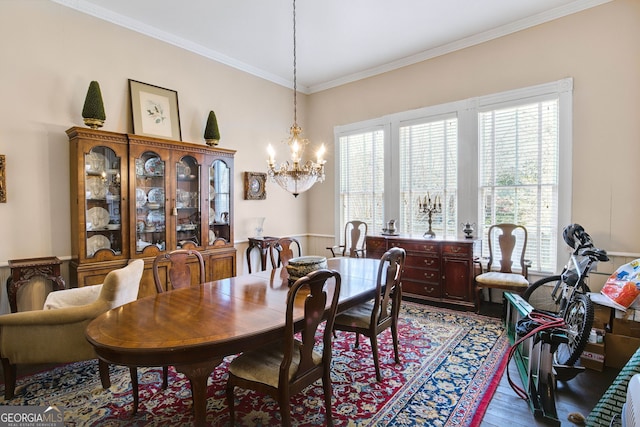 dining area featuring crown molding, a notable chandelier, and hardwood / wood-style flooring