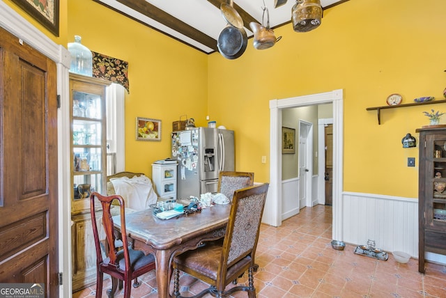 tiled dining space featuring beamed ceiling