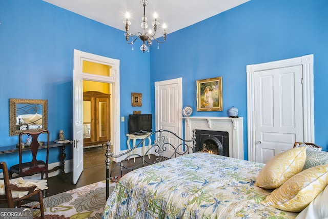 bedroom with a high ceiling, dark hardwood / wood-style floors, and a notable chandelier