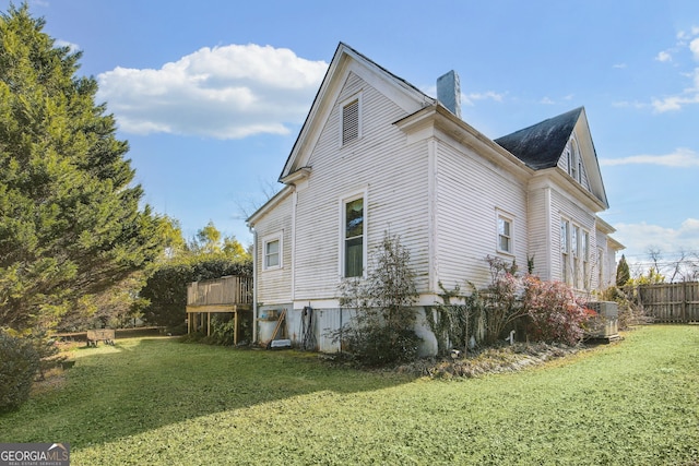 view of side of home featuring a yard and a deck