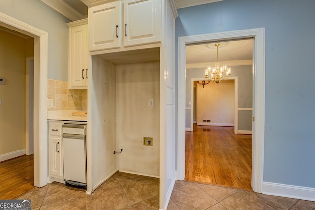 kitchen featuring white cabinetry, ornamental molding, light tile patterned flooring, and decorative backsplash