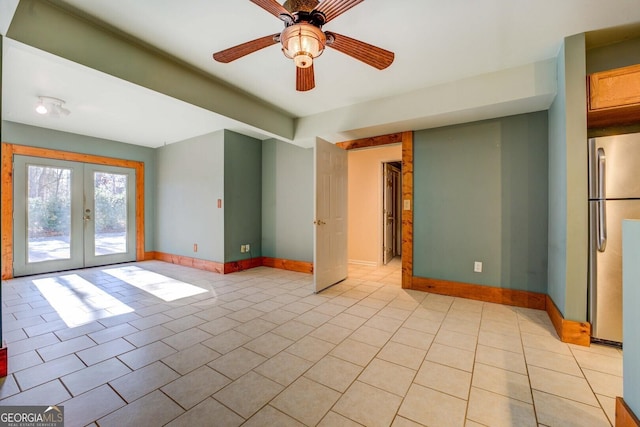 tiled empty room featuring french doors and ceiling fan