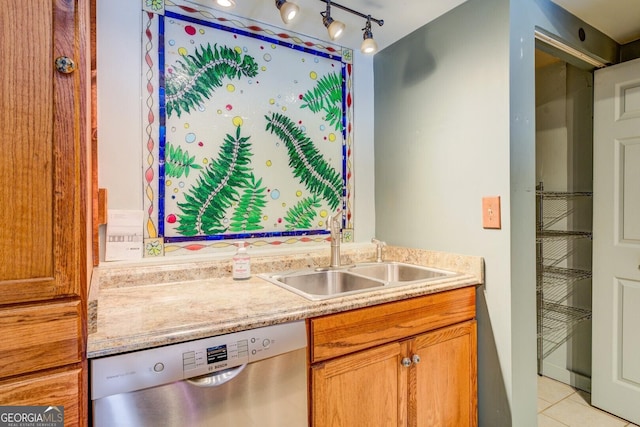 kitchen with light tile patterned flooring, stainless steel dishwasher, rail lighting, and sink