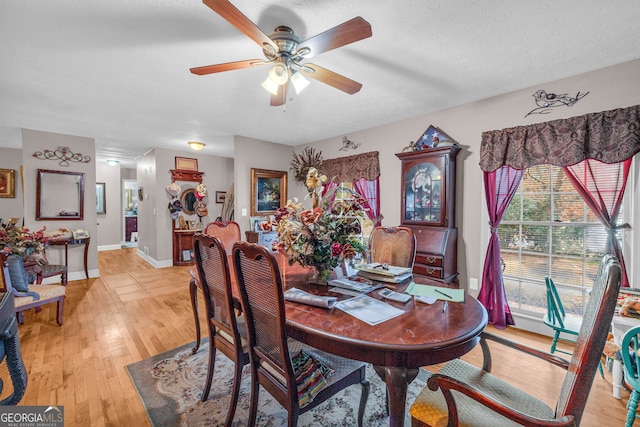 dining room with a textured ceiling, light hardwood / wood-style floors, and ceiling fan