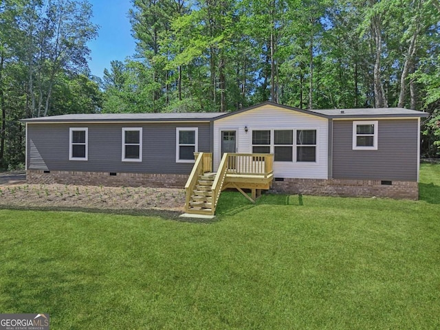 manufactured / mobile home featuring a deck and a front lawn