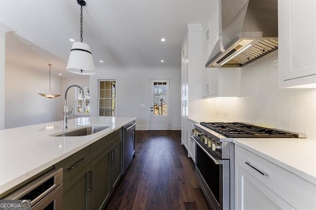 kitchen with white cabinetry, hanging light fixtures, wall chimney exhaust hood, and appliances with stainless steel finishes