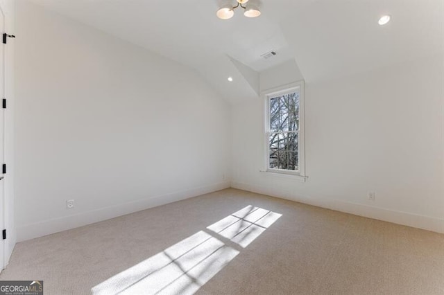 additional living space featuring an inviting chandelier, vaulted ceiling, and light colored carpet