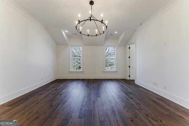 unfurnished dining area featuring dark hardwood / wood-style flooring, crown molding, and a chandelier