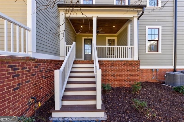 view of exterior entry with cooling unit, ceiling fan, and a porch