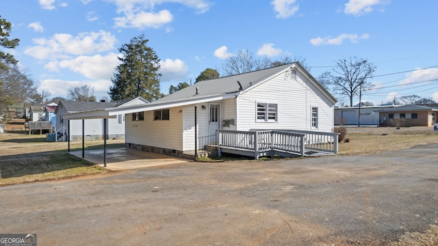 view of front of house featuring a carport and a wooden deck