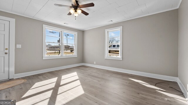 spare room with crown molding, ceiling fan, and light hardwood / wood-style floors