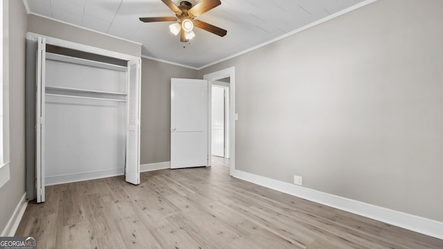 unfurnished bedroom with crown molding, ceiling fan, light hardwood / wood-style floors, and a closet