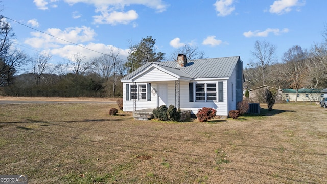 view of front of property featuring cooling unit and a front lawn