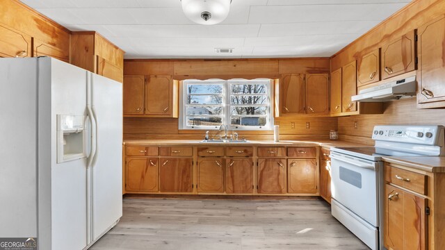 kitchen with sink, white appliances, and light wood-type flooring