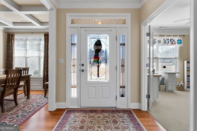 entrance foyer featuring crown molding, coffered ceiling, hardwood / wood-style floors, and beam ceiling