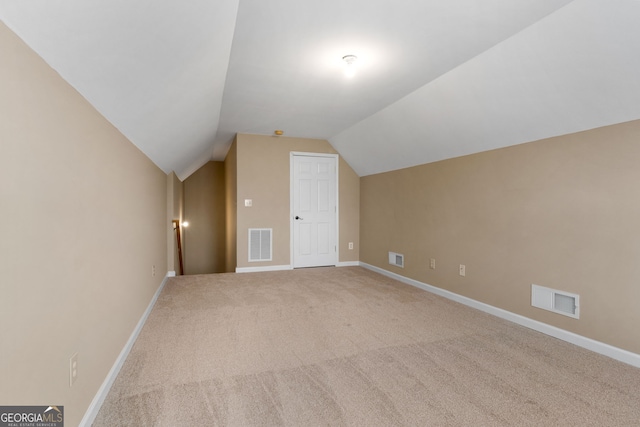 bonus room with lofted ceiling and carpet flooring