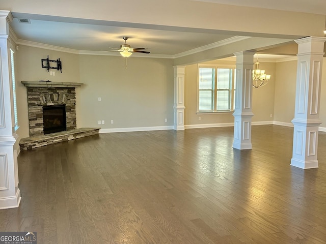 unfurnished living room featuring dark wood-type flooring, ceiling fan, a stone fireplace, and decorative columns