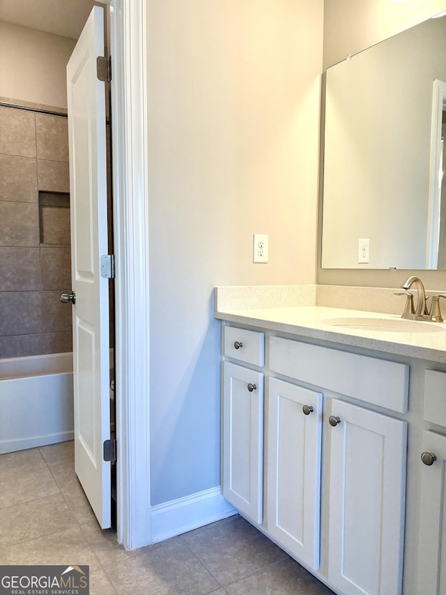 bathroom featuring tiled shower / bath combo, vanity, and tile patterned floors