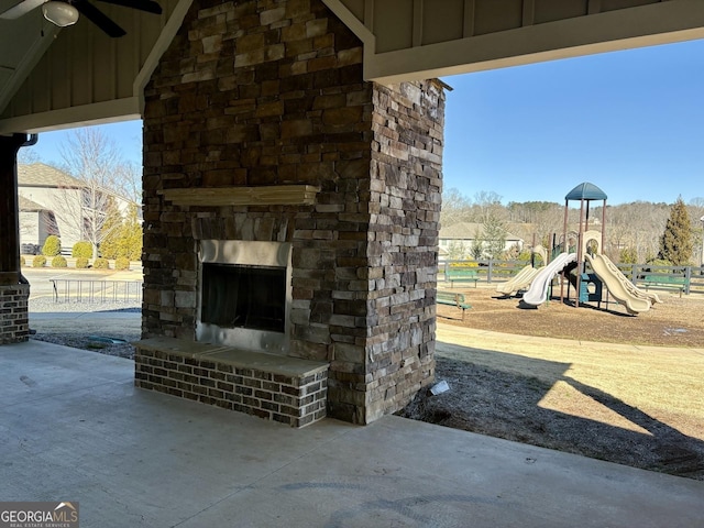 view of patio / terrace with a playground, ceiling fan, and an outdoor stone fireplace