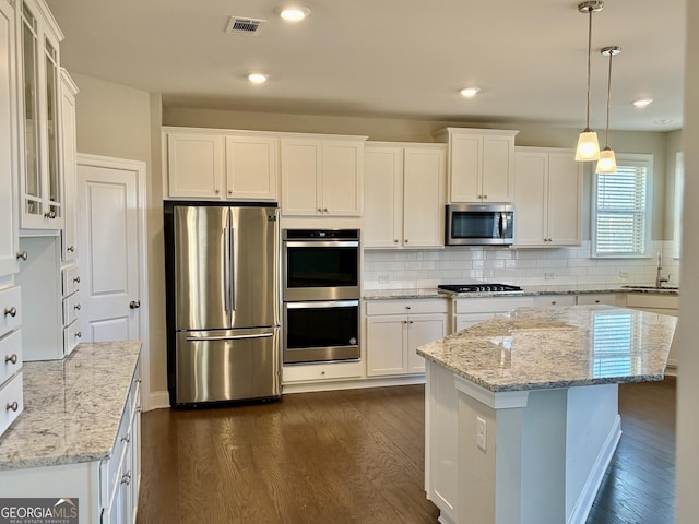 kitchen featuring white cabinetry, stainless steel appliances, sink, and a kitchen island