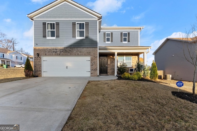 view of property with a garage, central AC unit, and a front yard