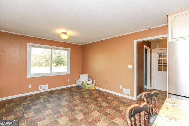 spare room with crown molding and a textured ceiling