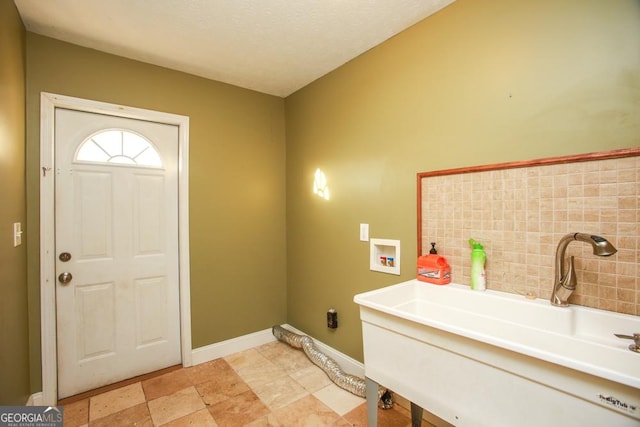 laundry area featuring sink, hookup for a washing machine, and a textured ceiling