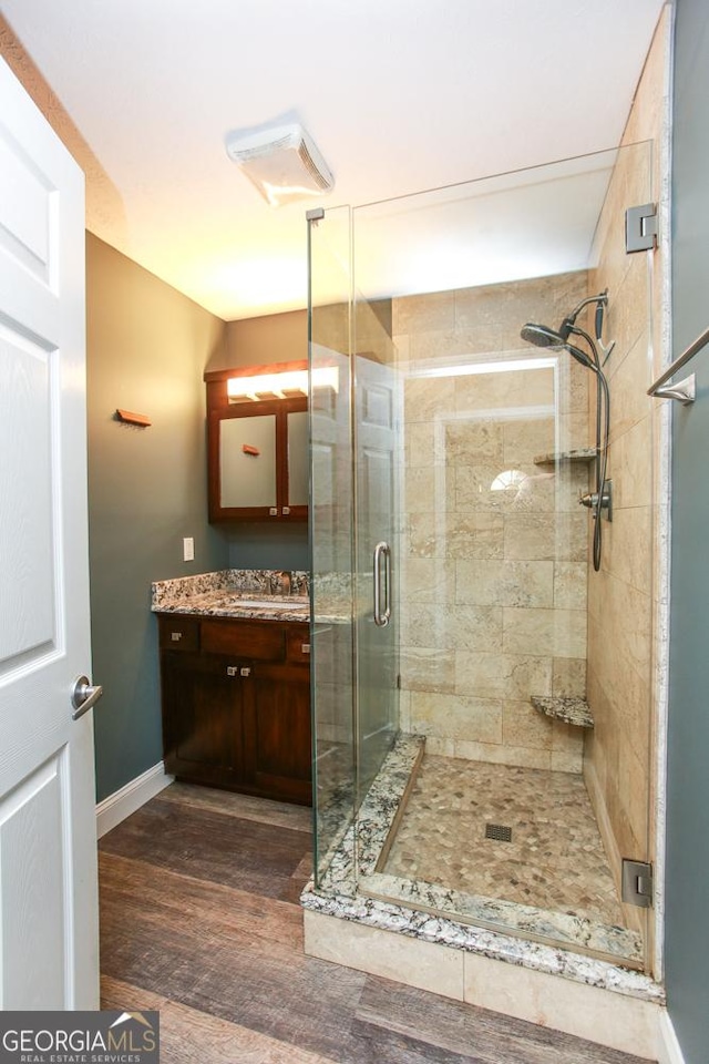 bathroom with vanity, an enclosed shower, and hardwood / wood-style floors