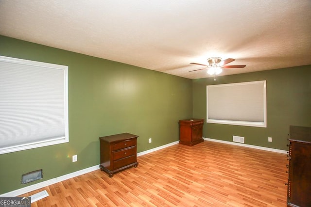 spare room with ceiling fan and light wood-type flooring