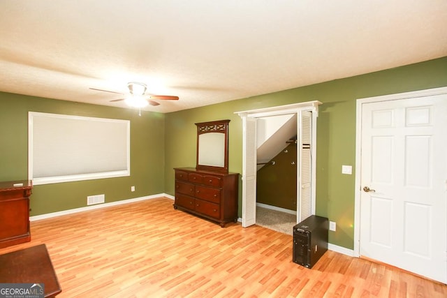 interior space with ceiling fan, light hardwood / wood-style floors, and a closet