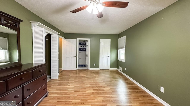 444 Agape Rd, Carrollton, GA 30116 - unfurnished bedroom featuring light wood-style floors, a textured ceiling, baseboards, and a ceiling fan