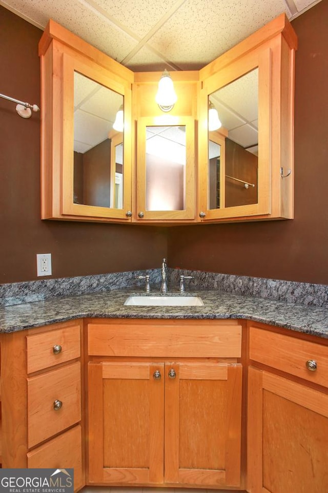 bathroom featuring a paneled ceiling and vanity