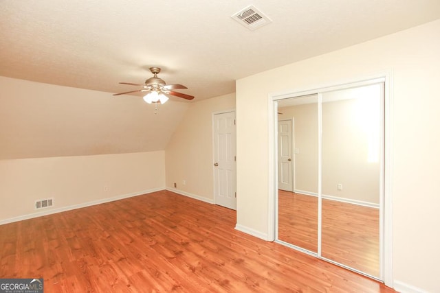 additional living space with lofted ceiling, hardwood / wood-style floors, a textured ceiling, and ceiling fan