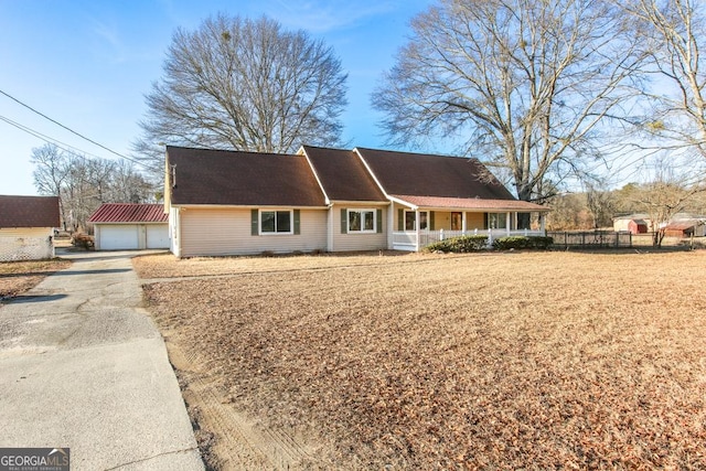 view of front facade with a garage, an outdoor structure, and covered porch