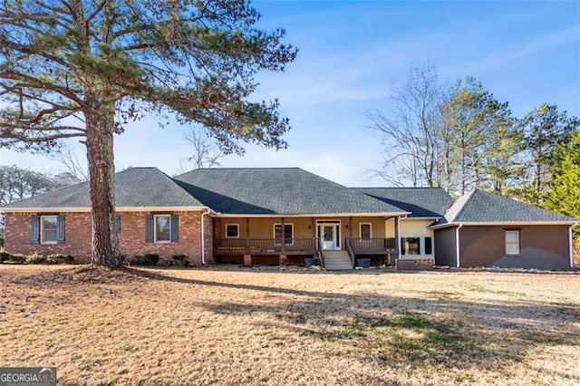 ranch-style house with a front yard and covered porch