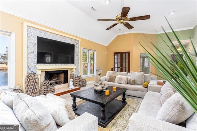 living room with crown molding, lofted ceiling, ceiling fan, and french doors