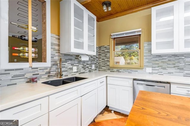 kitchen featuring tasteful backsplash, stainless steel dishwasher, sink, and white cabinets