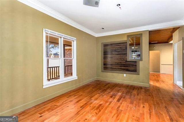 empty room featuring ornamental molding and wood-type flooring