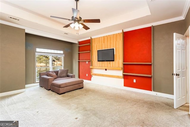 carpeted living room featuring crown molding, ceiling fan, and a raised ceiling