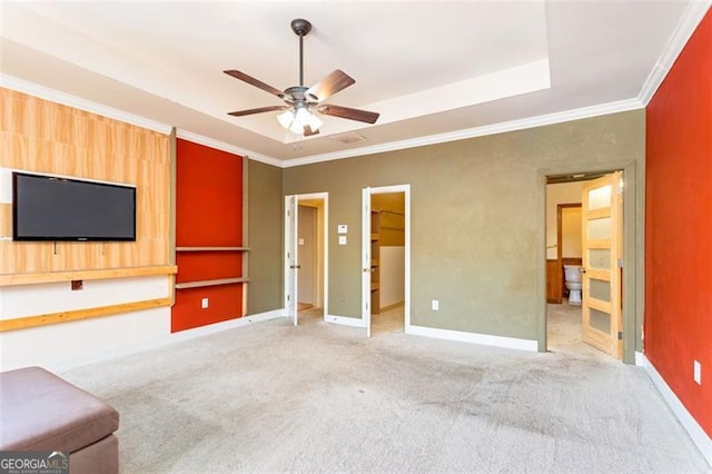 unfurnished living room featuring crown molding, light colored carpet, a raised ceiling, and ceiling fan