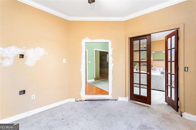 empty room featuring crown molding, light colored carpet, and french doors