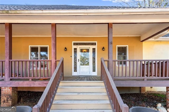 view of exterior entry featuring covered porch