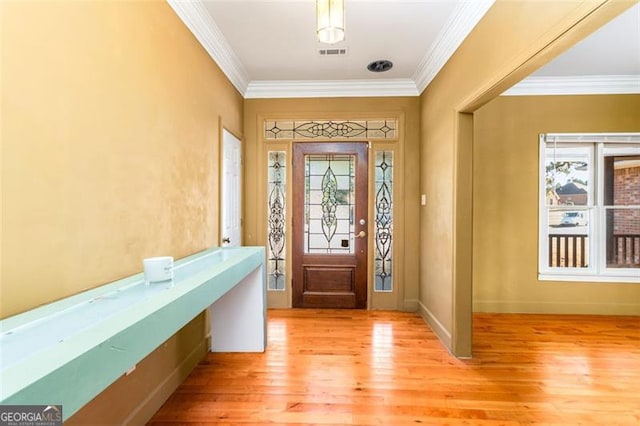 foyer with ornamental molding, light hardwood / wood-style floors, and a wealth of natural light