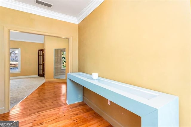 corridor featuring light hardwood / wood-style flooring and ornamental molding