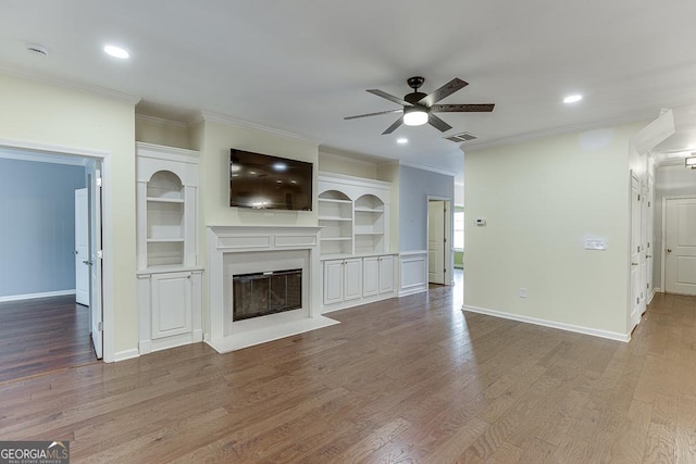 unfurnished living room with hardwood / wood-style floors, ornamental molding, and ceiling fan