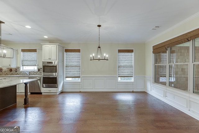 kitchen featuring appliances with stainless steel finishes, dark wood-style floors, and an inviting chandelier